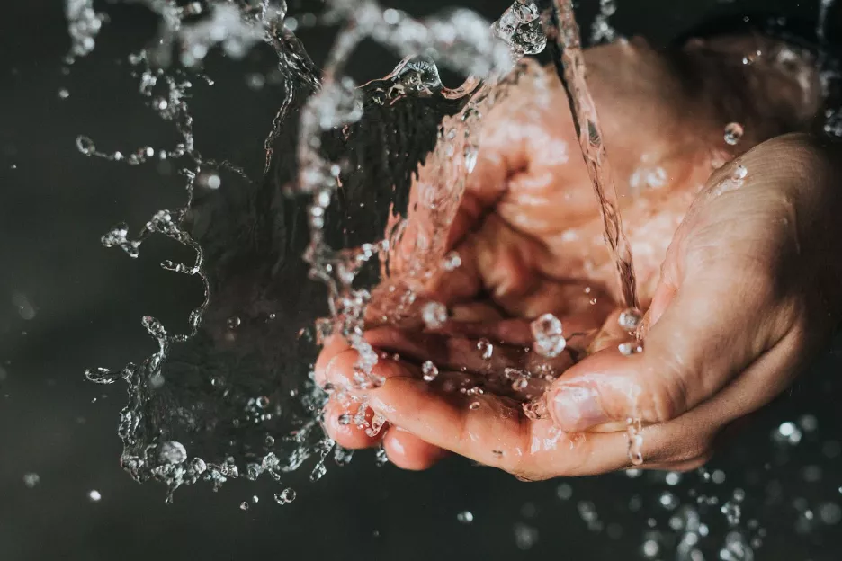 Cupped hands holding clear water