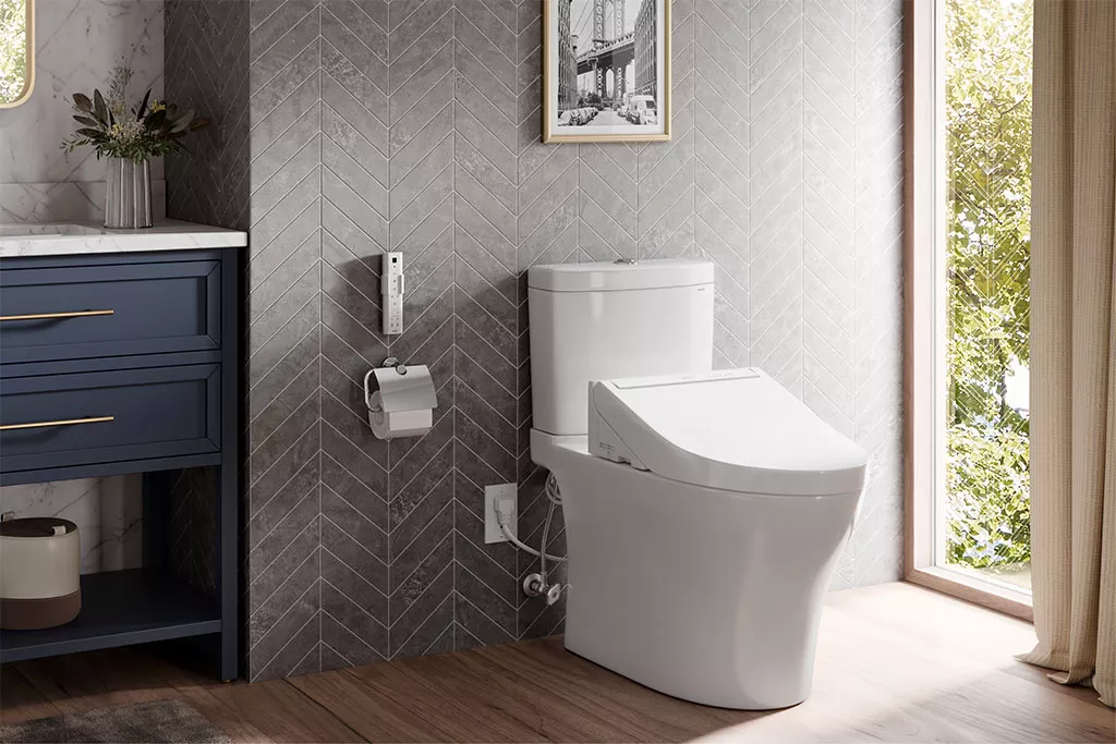 A TOTO WASHLET+ C5 two-piece toilet adds comfort and elegance to a bright bathroom with wood floors and chevron tile walls.