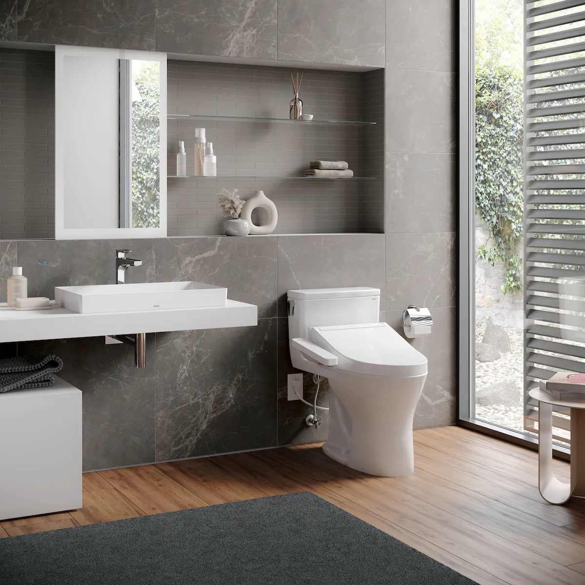 Minimalist bathroom featuring a one-piece WASHLET+ bidet toilet and floating sink with warm gray tile and natural light.