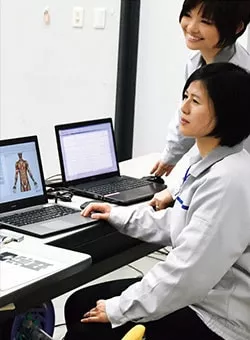 Photo of TOTO engineers with laptop computers looking at ergonomic issues.