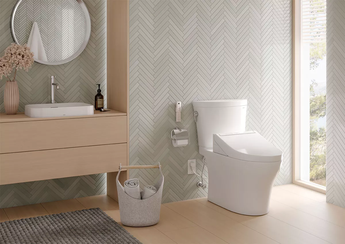 A TOTO Aquia toilet with a C5 WASHLET bidet seat attachment in a sunlit bathroom.