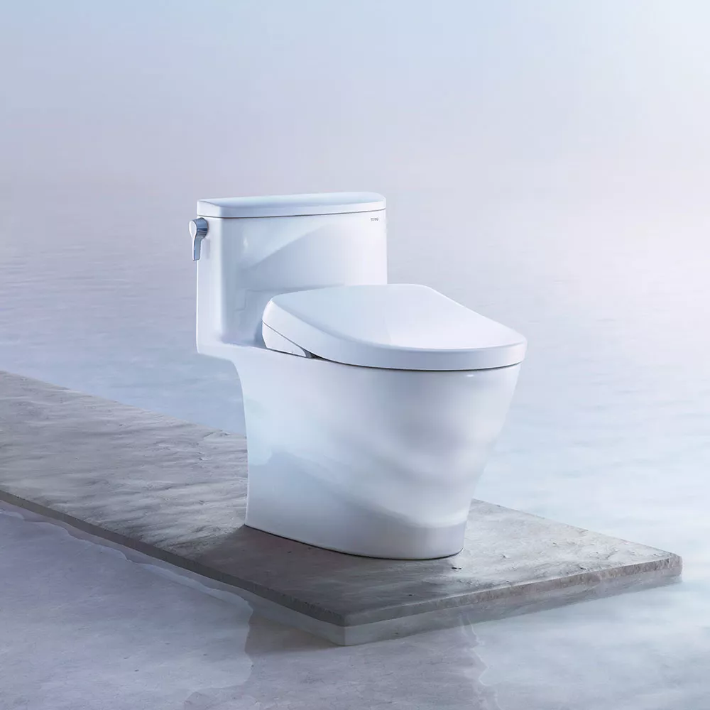 A TOTO WASHLET S7 Bidet Seat is displayed on a platform above clear blue water.