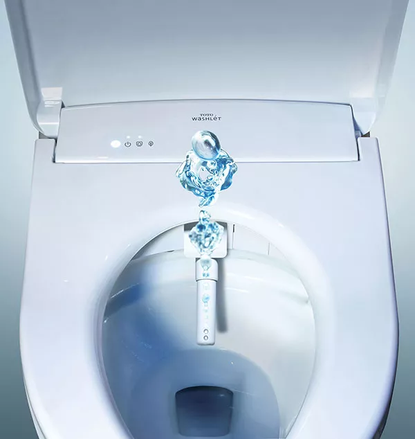 TOTO WASHLET bidet seat close-up with water spray feature activated — high-tech hygiene-focused bathroom technology.