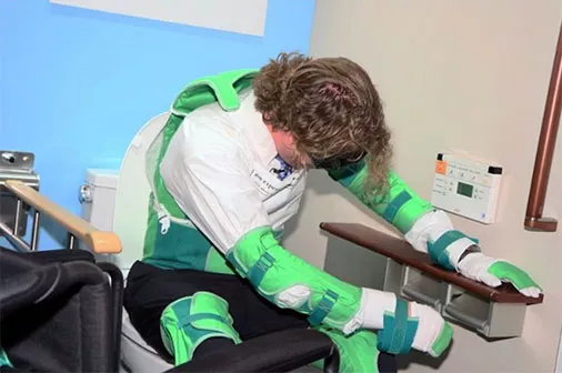 A design professional participates in a physical impairment simulation to better understand the importance of universal bathroom design